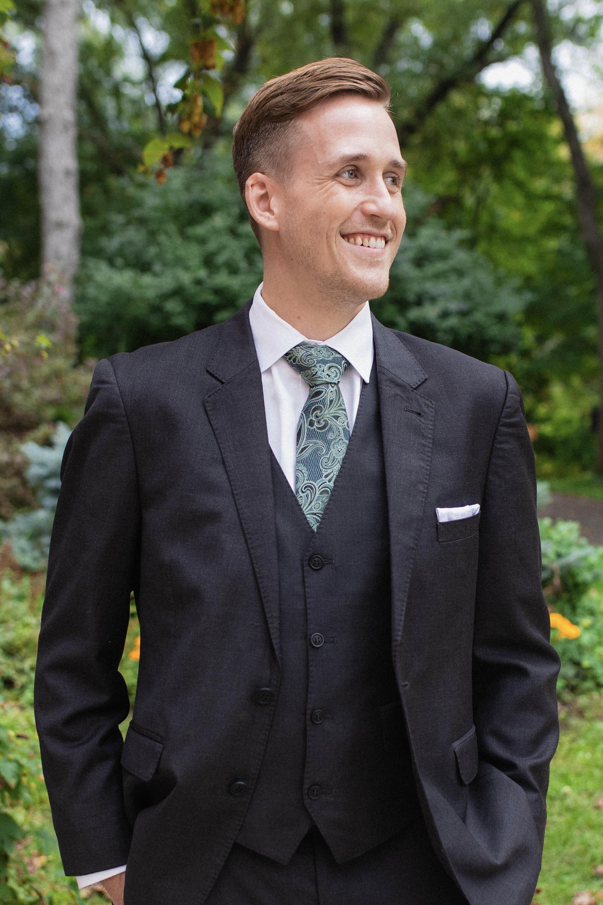Tanner Livesay outdoors wearing a dark suit and patterned tie.